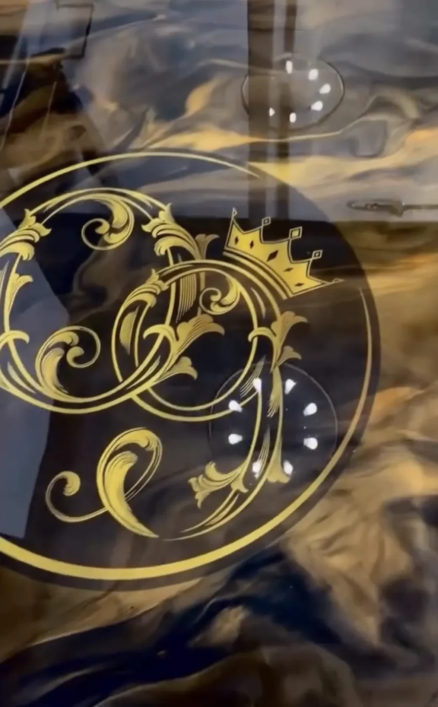 Gold logo set into a metallic epoxy floor